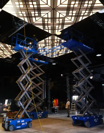 Lifts and rigging in place during the installation of an exhibition in a venue.